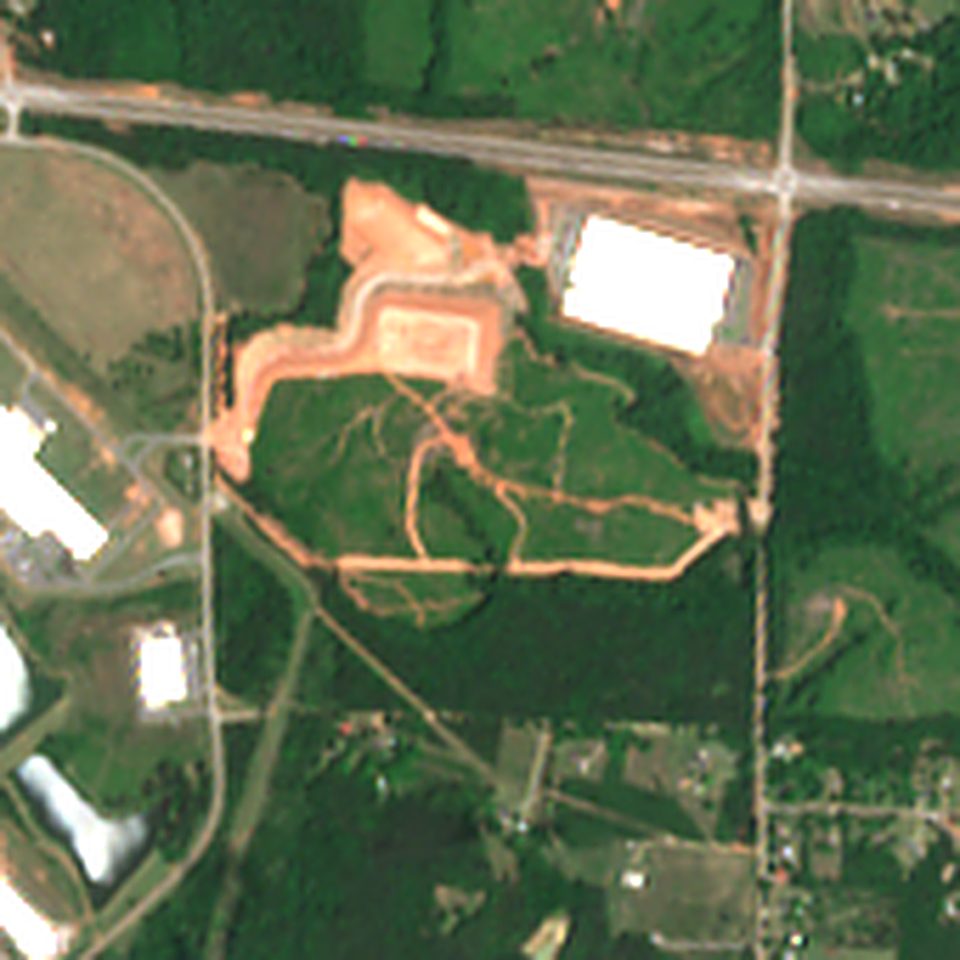 Satellite view in May 2026: grass and scrub crossed by dirt tracks
